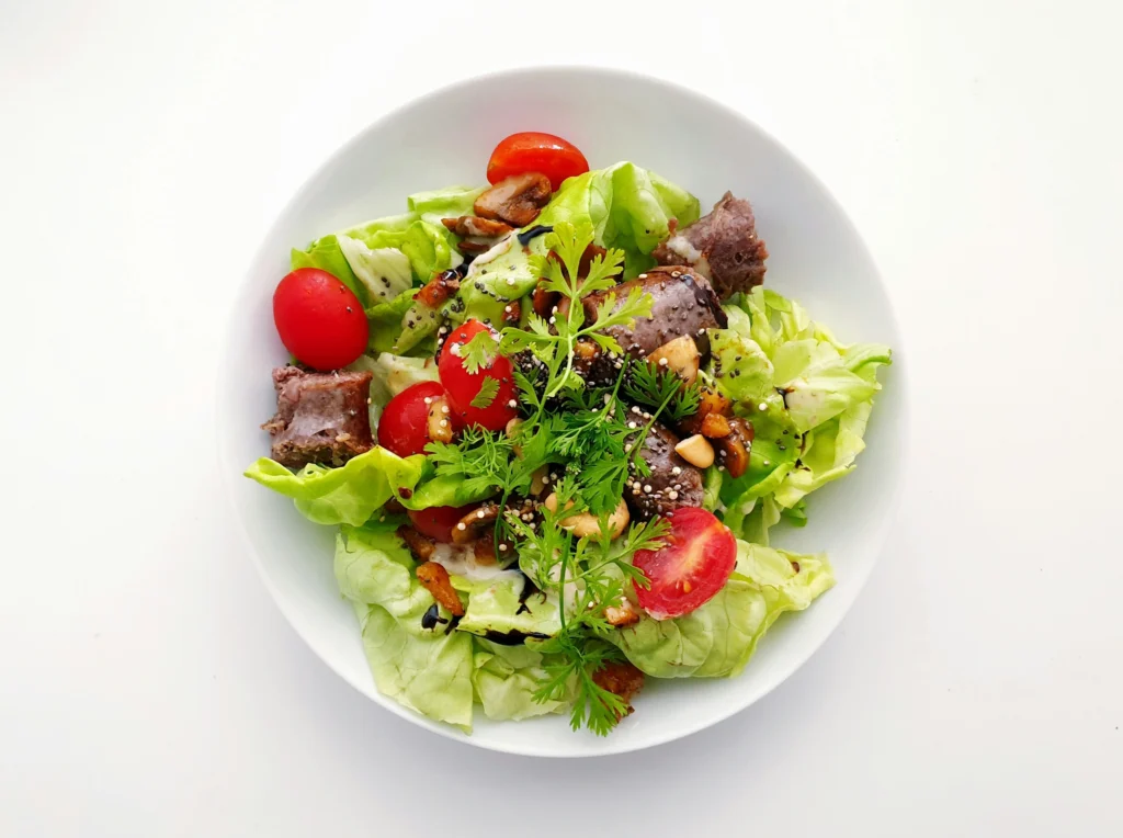 Caesar Greek salad with butter lettuce, seared beef cubes, cherry tomatoes, candied nuts and balsamic glaze