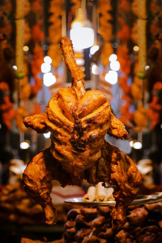 Quarter chicken dinner roasted to golden perfection, displayed on a skewer with crispy charred skin and juicy meat